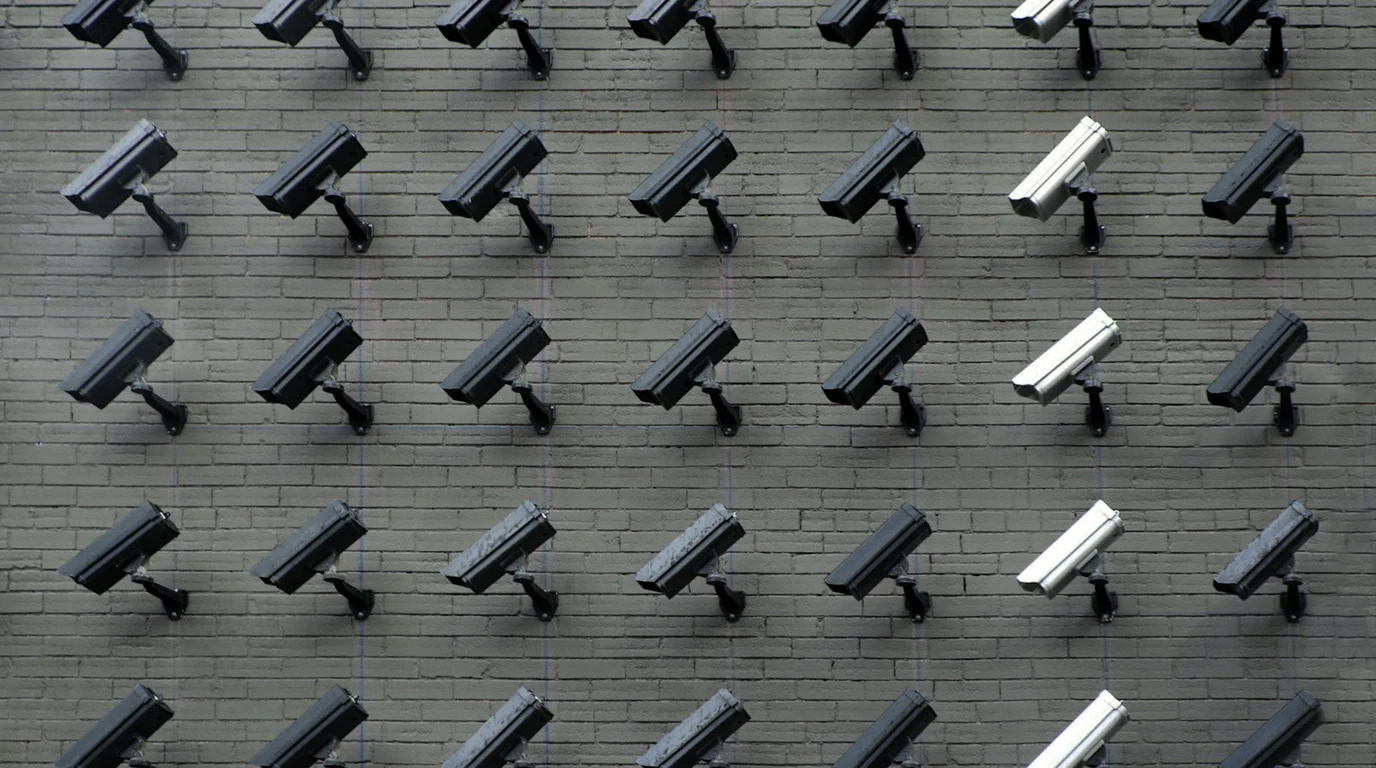 Commercial outdoor 4K PoE security camera mounted on building facade with low-light night illumination
