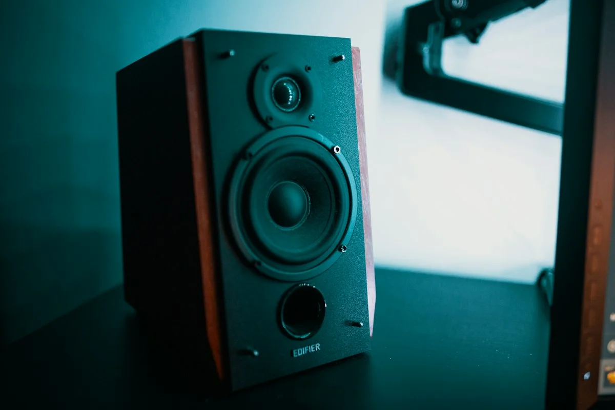 Precision high-excursion home theater subwoofer driver exposed showing heavy magnet assembly in listening room